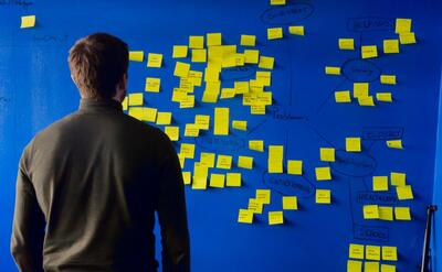 A man is standing in front of post it notes.
