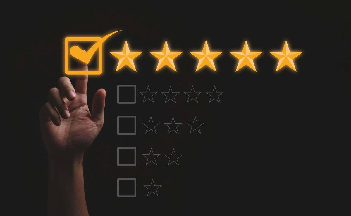 Hand selecting a 5-star rating with glowing checkmark on a dark background.