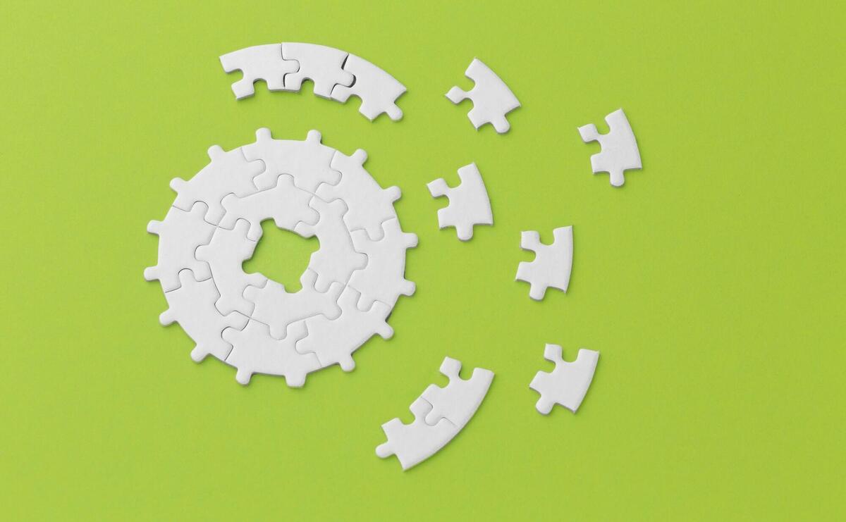 White puzzle pieces scattered on a bright green backdrop, symbolizing problem-solving.