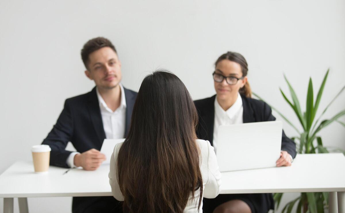 Headhunters interviewing female job candidate.