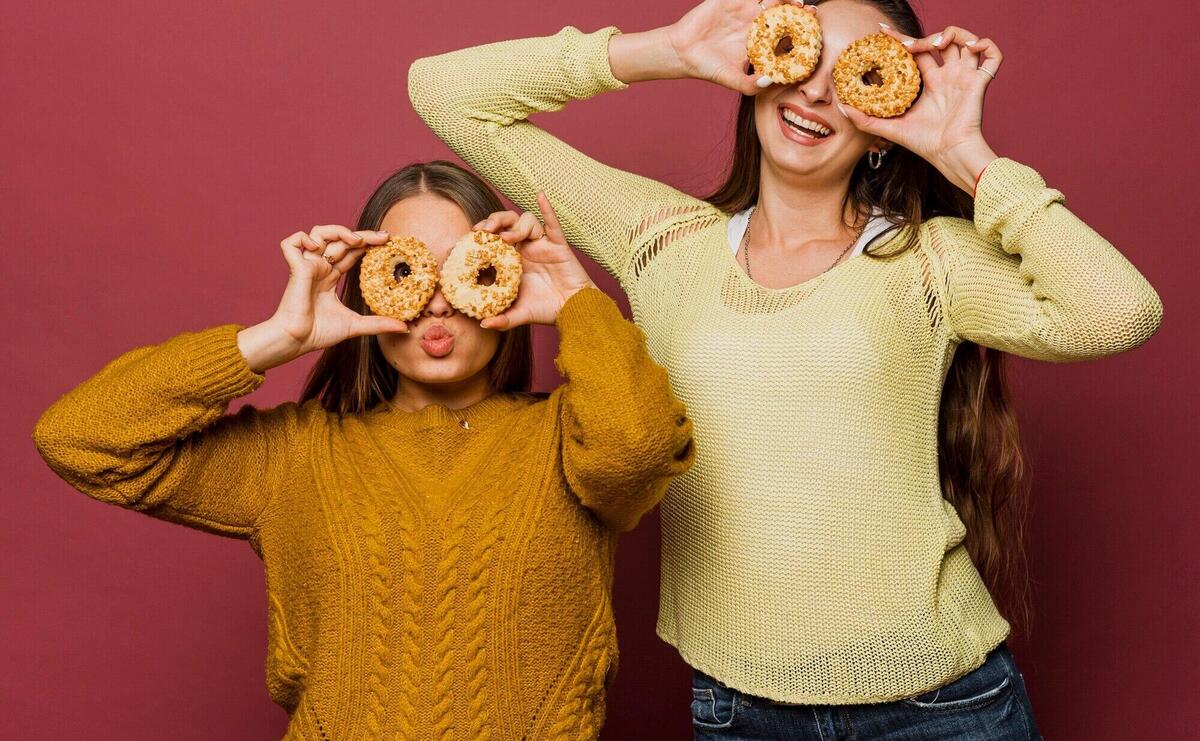 Medium shot happy girls with doughnuts